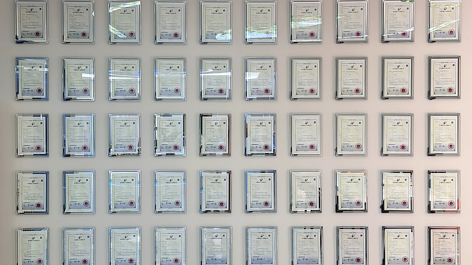 Chengda design-patent certificate wall — 50+ registered patents