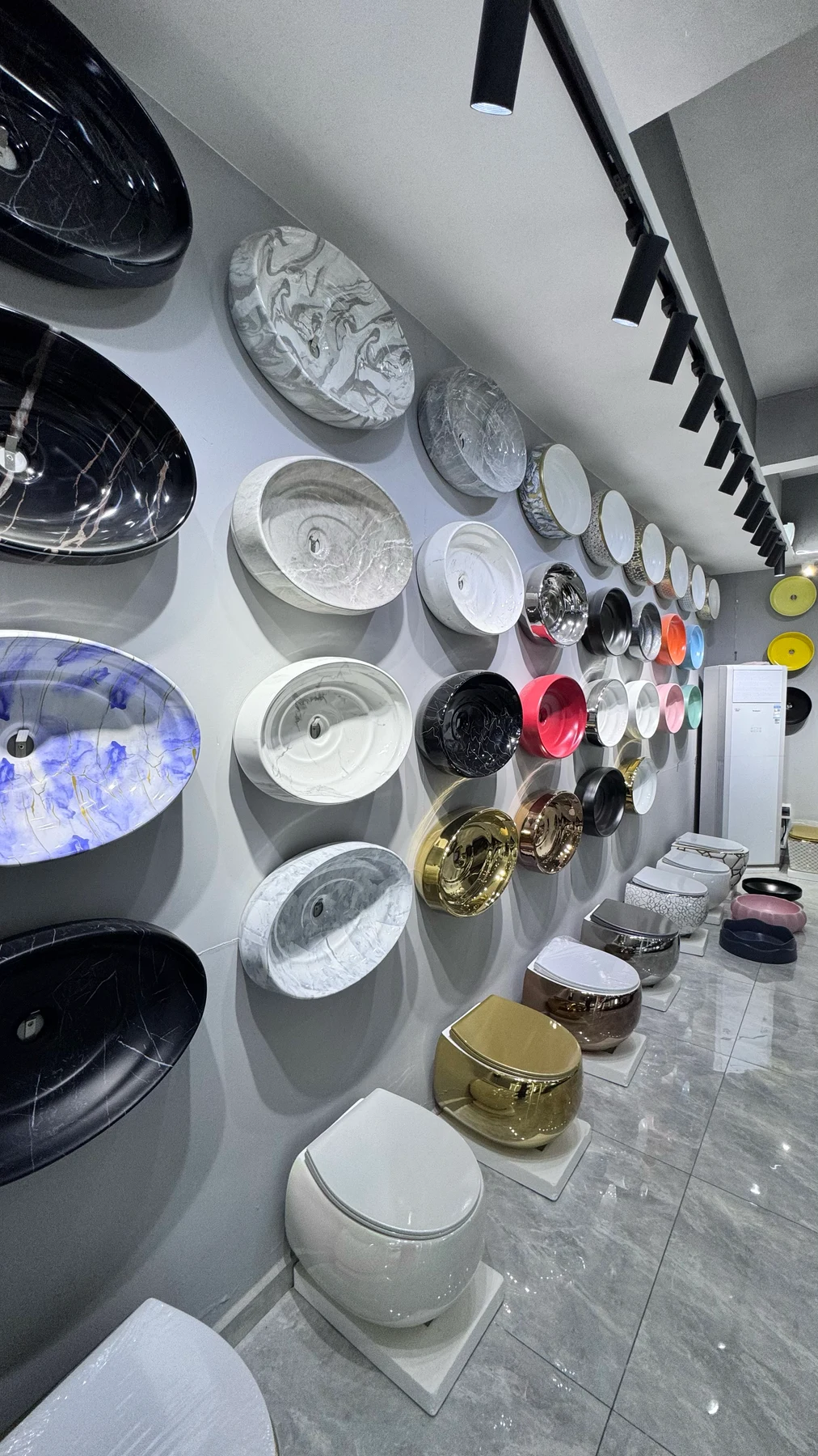 展廳牆面陳列的大理石紋、白瓷與描金面盆