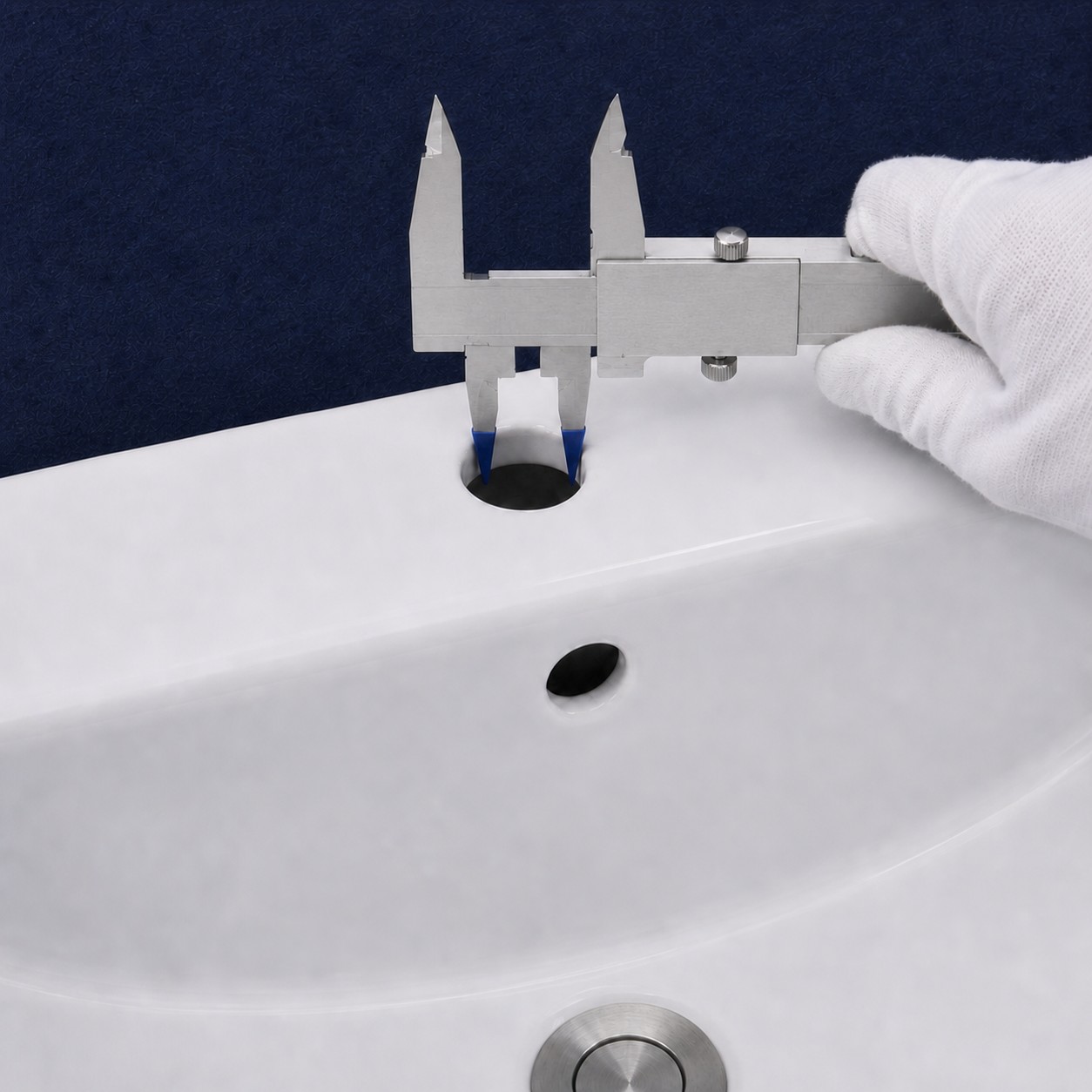 Caliper checking the diameter of a bathroom basin faucet hole without damaging the glaze