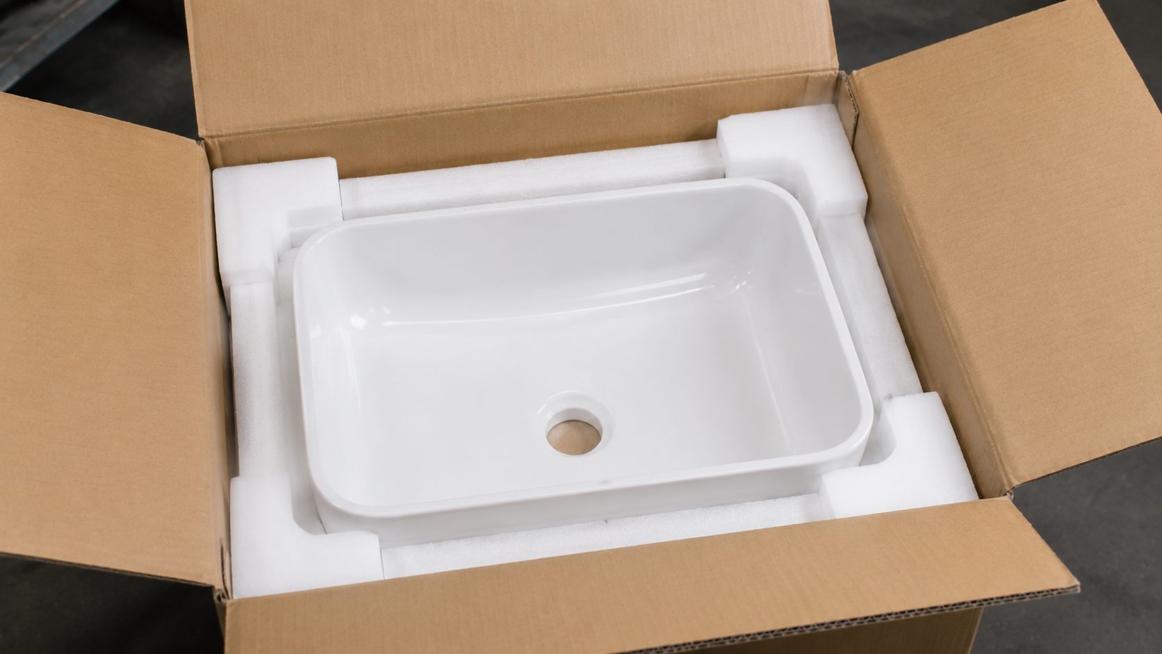 Finished ceramic wash basins being packed into export cartons and stacked on pallets before container loading