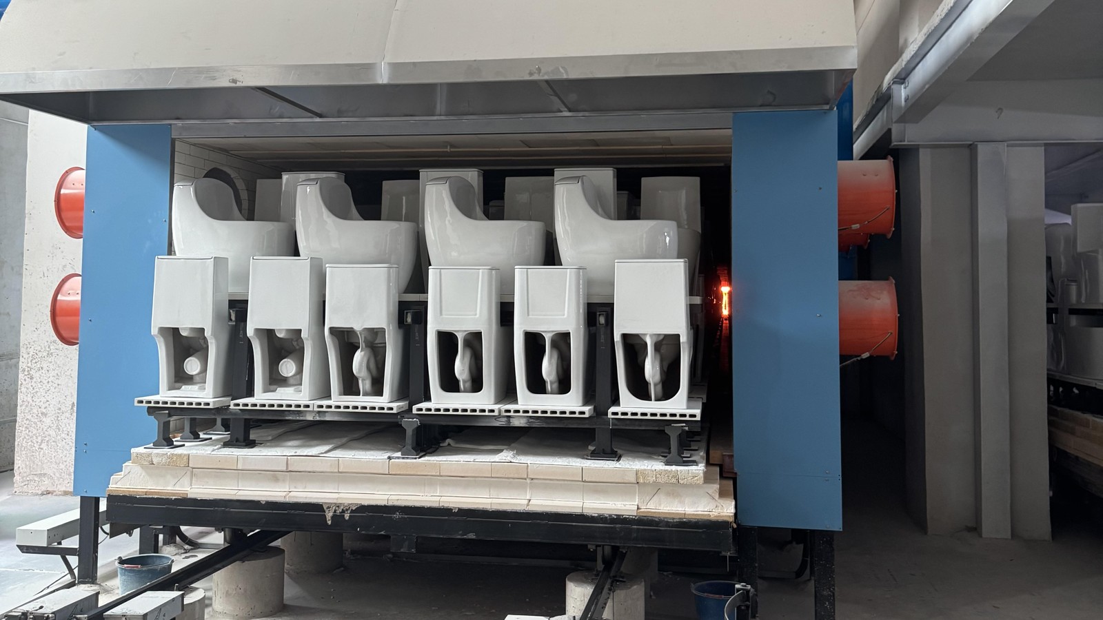 Ceramic sanitaryware on a kiln car entering a tunnel kiln fired at 1,250 °C at the Chengda factory in Chaozhou, China