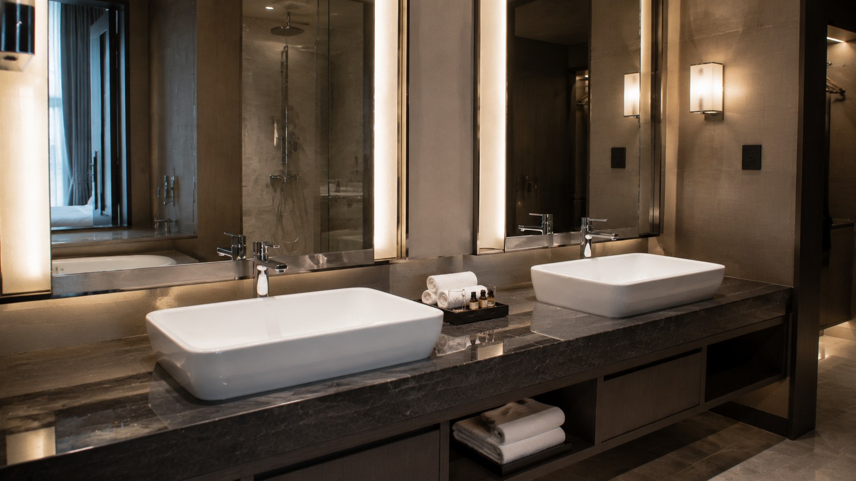 Porcelain vitreous china countertop basin installed in a modern hotel bathroom vanity