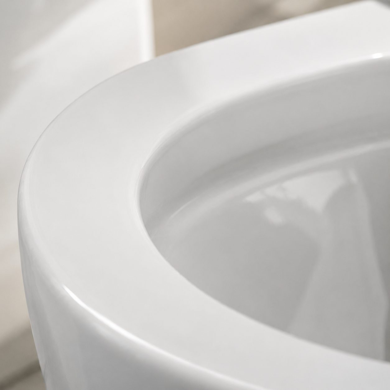 Top-down view into a white ceramic rimless toilet bowl showing the smooth open rim with no hidden under-rim channel