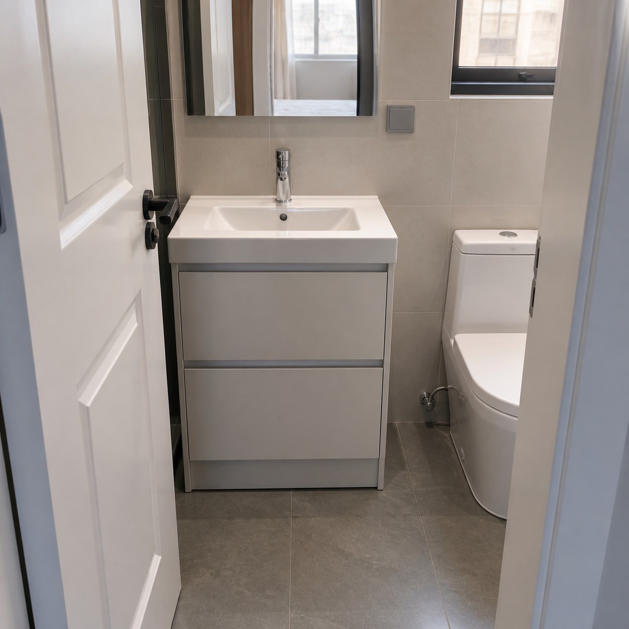 Shallow vanity basin cabinet clearing an inward-opening bathroom door