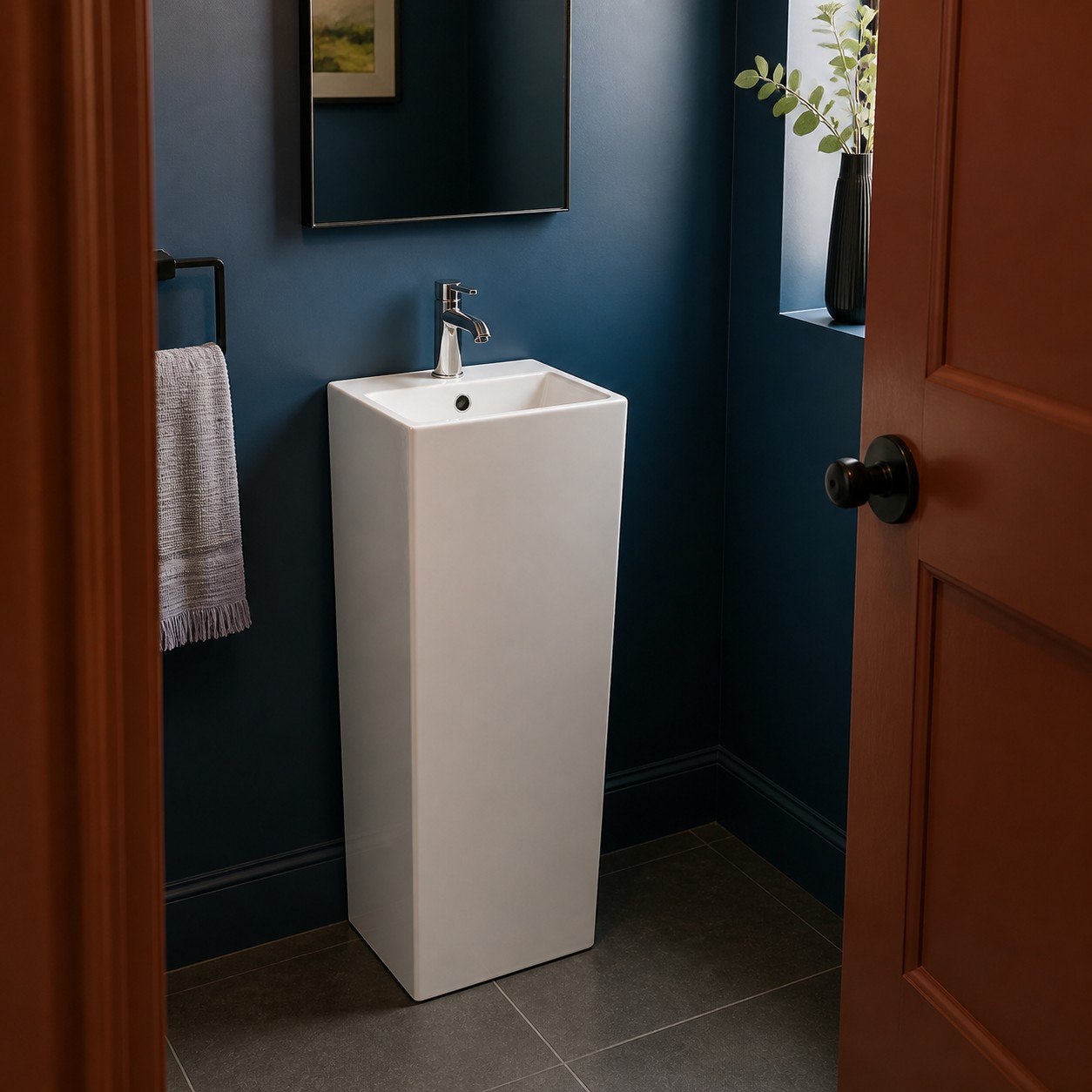 Slim freestanding column basin in a narrow cobalt powder room
