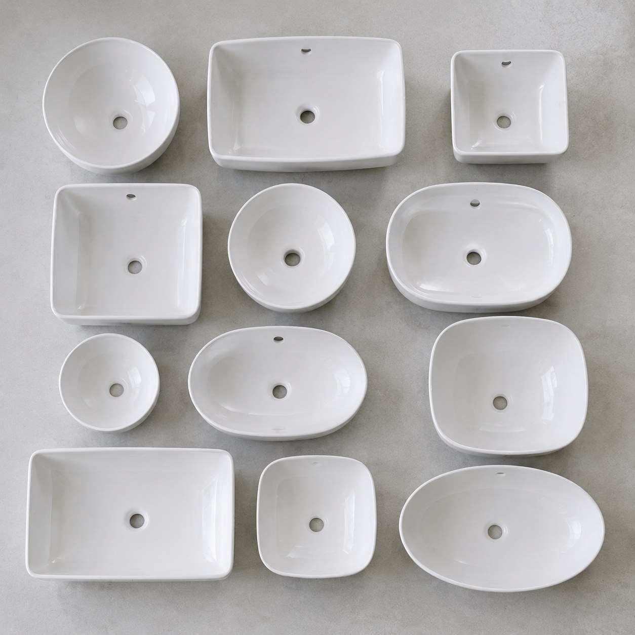 A tidy lineup of different wholesale ceramic wash basin models in various shapes and sizes shown as a product range